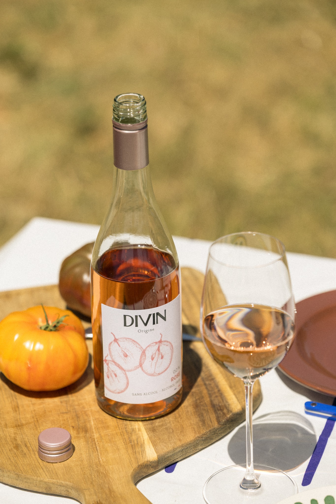 DIVIN Rosé 0,0 % am Tisch mit Glas und Tomaten