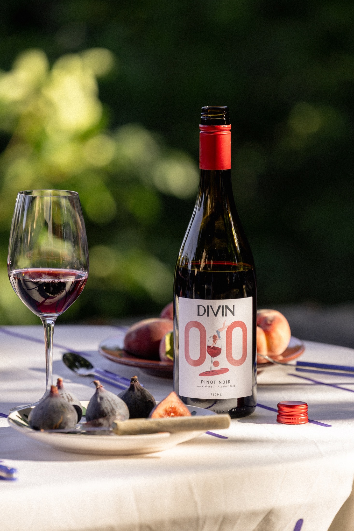 DIVIN Pinot Noir 0,0 % am Tisch mit Glas und Feigen